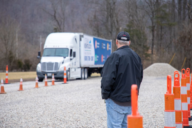 instructor watching student backing up big rig truck