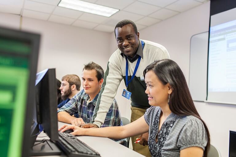 guy assisting student in computer lab