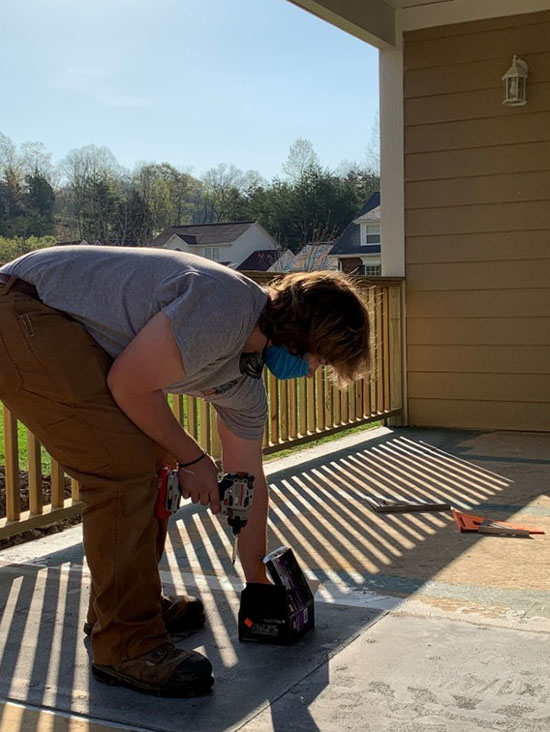 Student using drill to build house