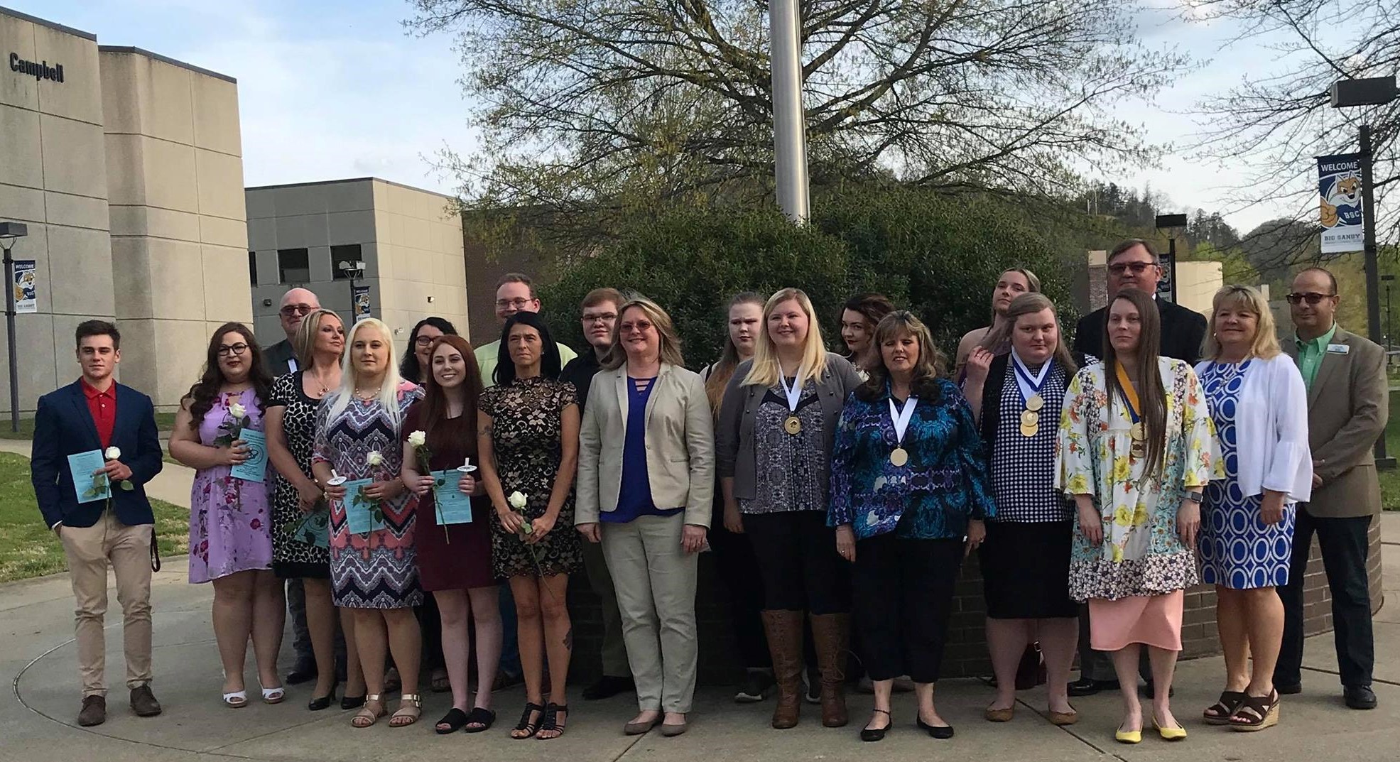 PTK Members in front of flag pole standing.